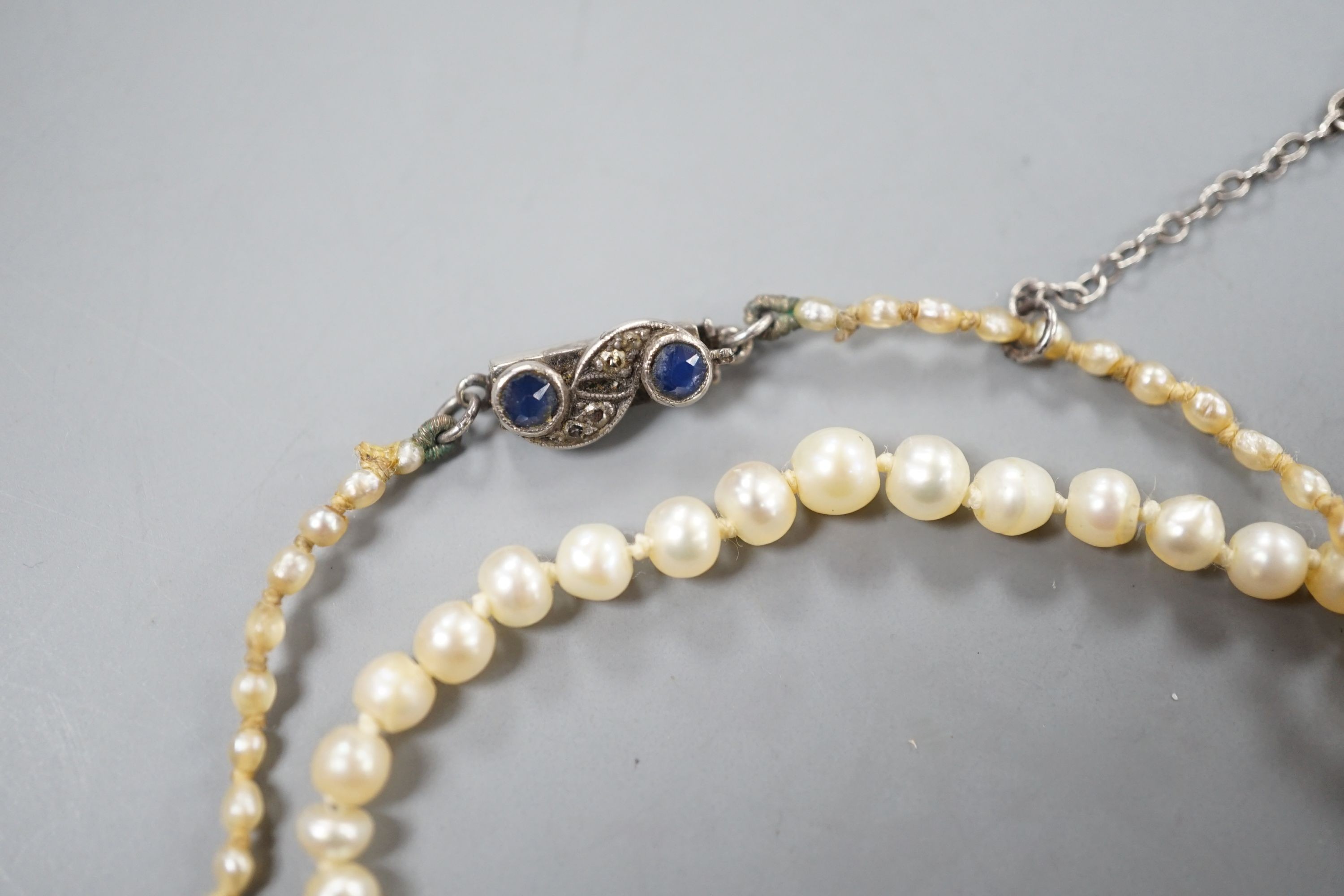 An Edwardian single strand graduated natural saltwater pearl necklace, with sapphire and diamond chip set clasp, 38cm, gross weight 5.7 grams, with accompanying Gem & Pearl Laboratory report dated 1/2/2022.